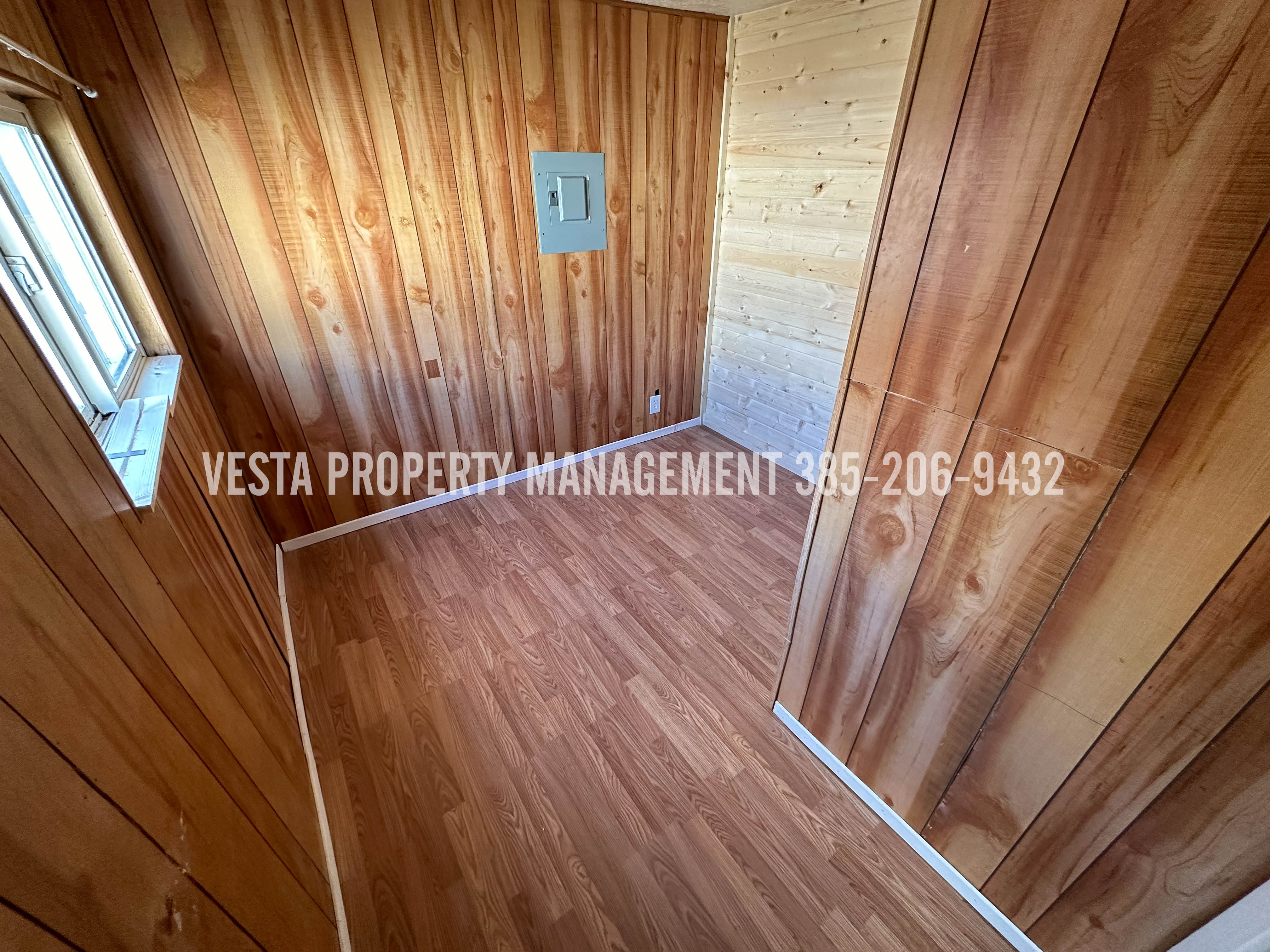 Unfurnished room featuring wood walls and wood finished floors
