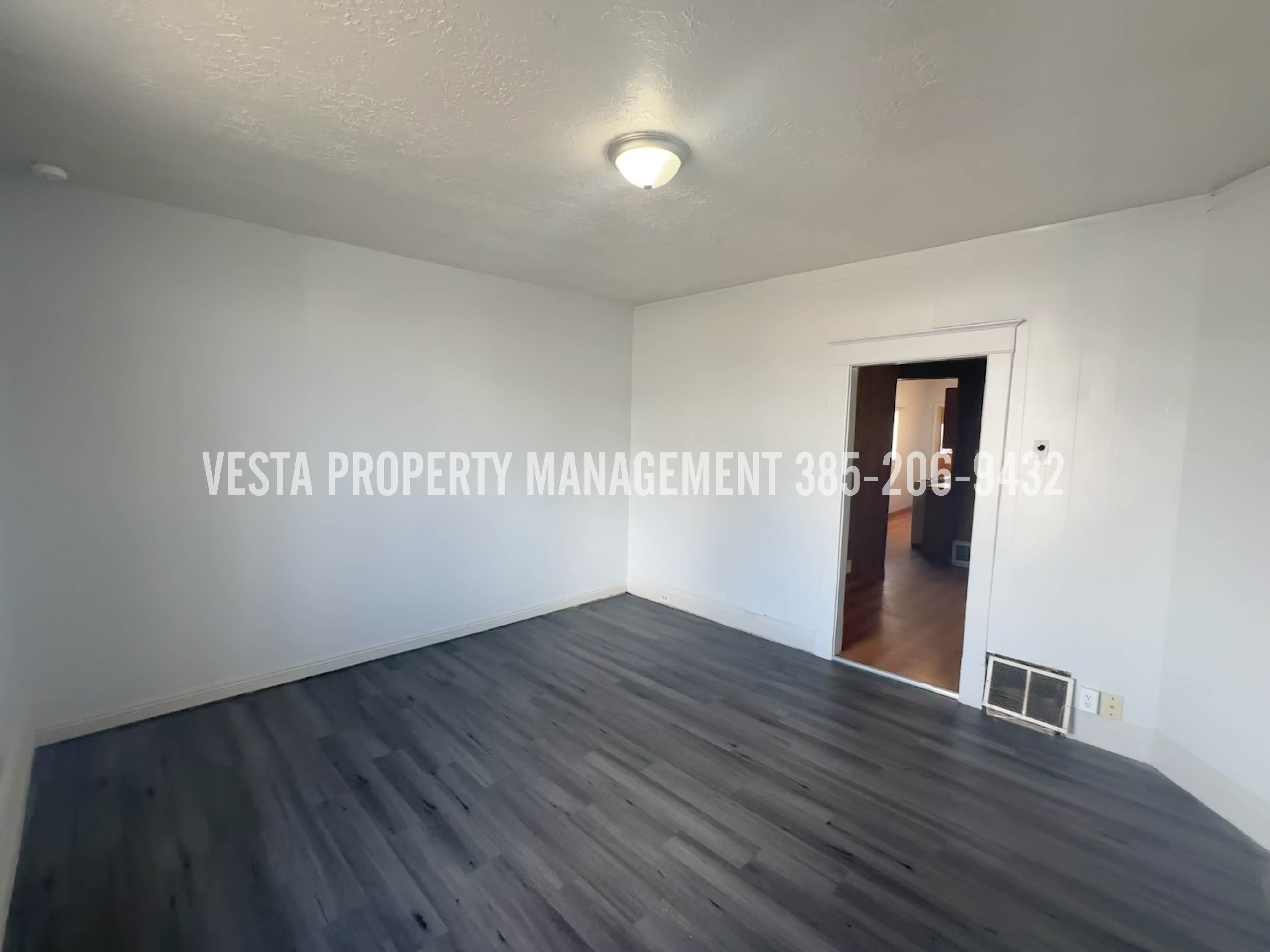 Empty room with dark wood finished floors and a textured ceiling