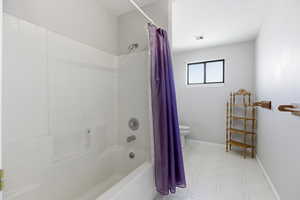 Full bath with light flooring and shower / tub combo
