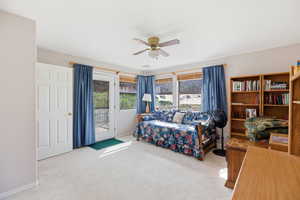 Bedroom featuring light colored carpet, access to outside, and ceiling fan