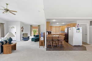 Dining space with light colored carpet and a ceiling fan