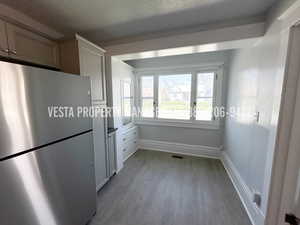 Kitchen with freestanding refrigerator and light wood-type flooring