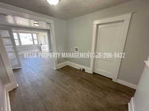 Unfurnished room featuring dark wood-style floors and a textured ceiling