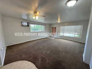 Carpeted empty room with a ceiling fan and baseboards