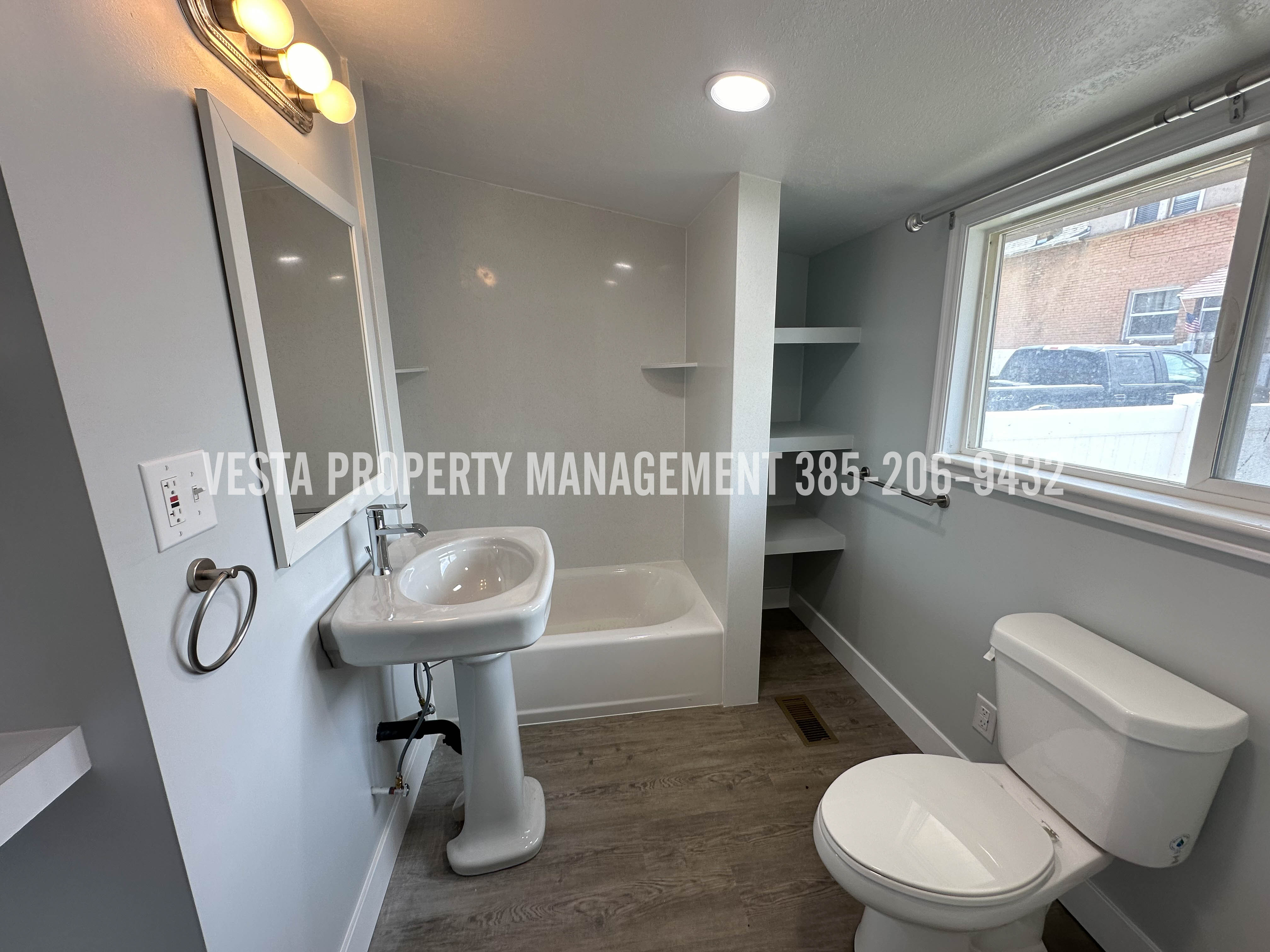 Bathroom with dark wood-style flooring and a bathtub