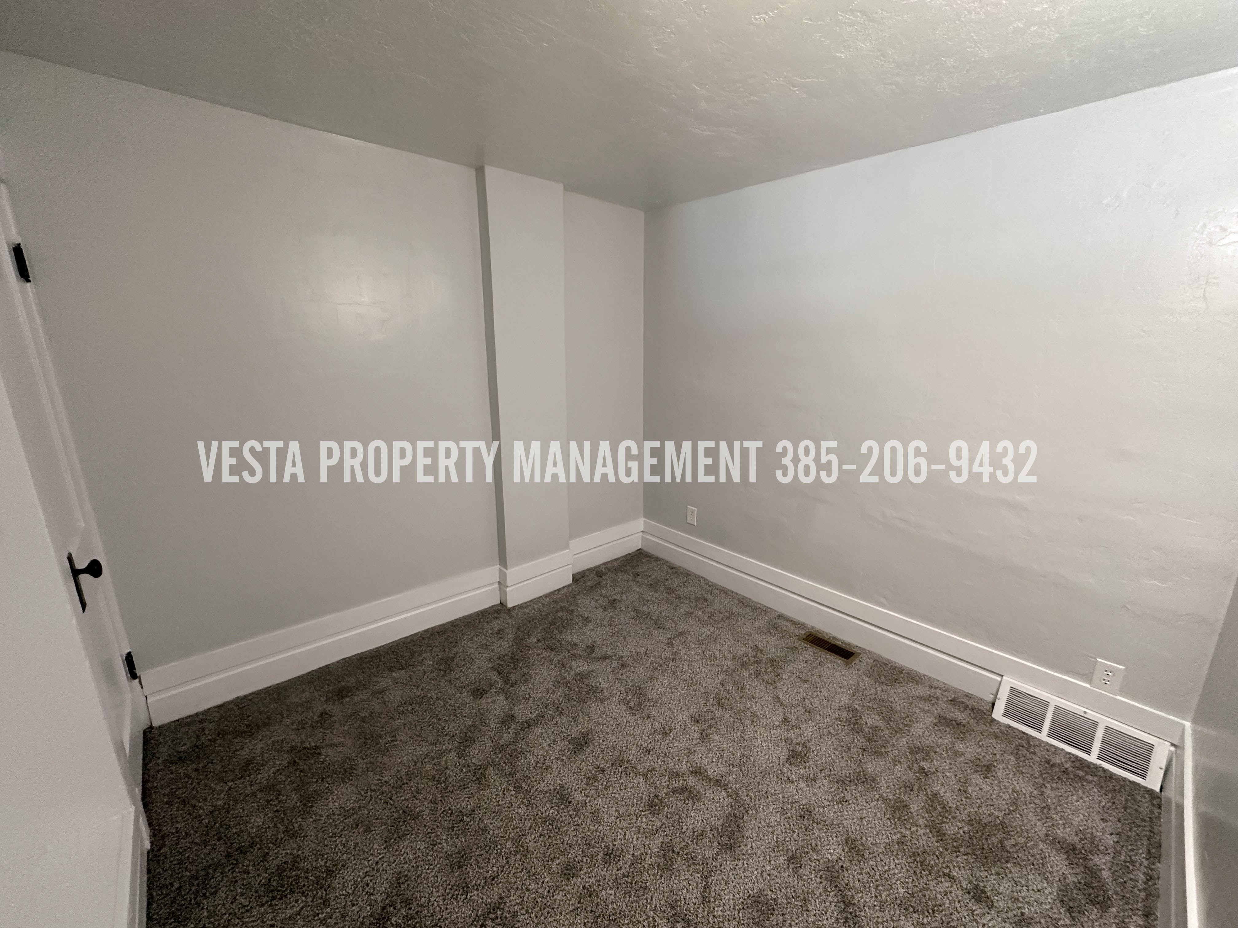 Spare room with dark colored carpet and a textured ceiling