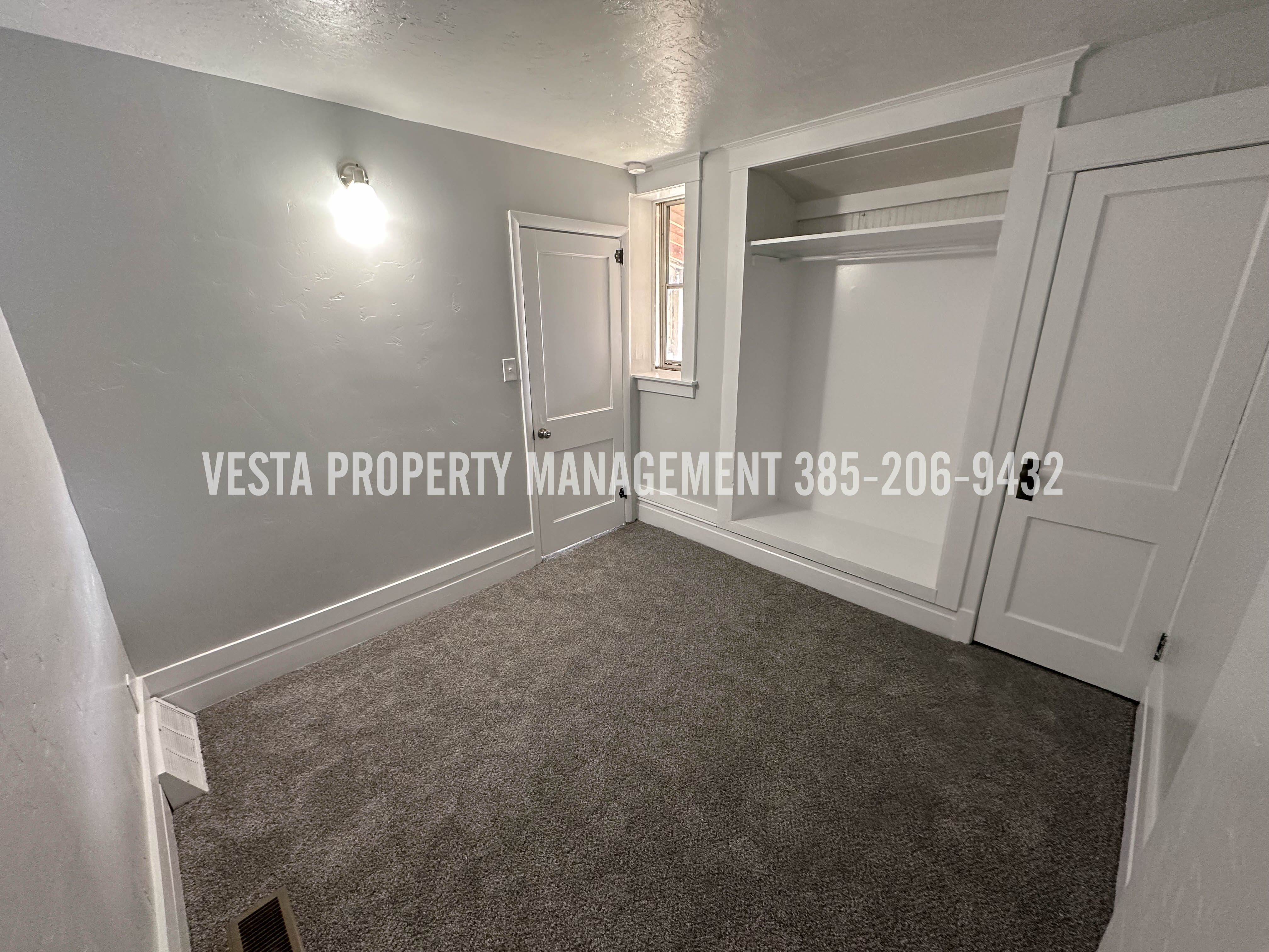 Unfurnished bedroom featuring a textured ceiling, dark colored carpet, and a closet