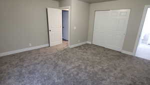 Unfurnished bedroom with carpet and a closet