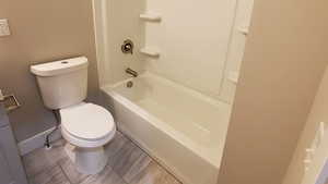 Full bathroom featuring toilet and washtub / shower combination