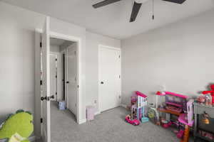 Playroom featuring light colored carpet and a ceiling fan