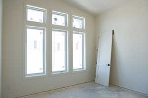 Empty room with lofted ceiling
