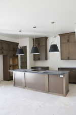 Kitchen featuring a kitchen island, decorative light fixtures, and dark wood finish cabinets