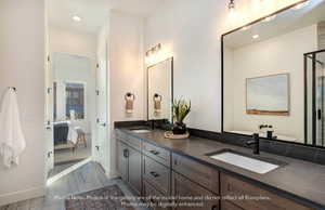 Ensuite bathroom with double vanity, light wood-style flooring, and recessed lighting