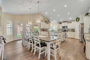 Dining space with light wood-style floors, lofted ceiling, and hanging lights