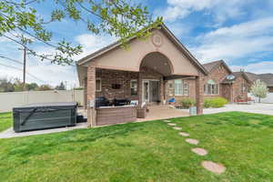 Rear view of house featuring a patio, brick siding, an outdoor hangout area, and a fenced backyard
