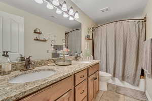 Bathroom with double vanity and shower / tub combo