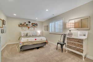 Bedroom with light colored carpet and recessed lighting