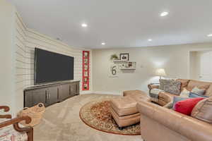 Living area featuring light colored carpet and recessed lighting