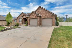 View of front facade with concrete driveway, brick siding, and an attached garage