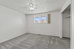 #813 Bedroom with a closet, ceiling fan, carpet floors, and a textured ceiling