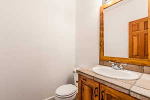 Half bathroom featuring vanity and toilet