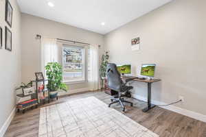 Office space with wood finished floors and recessed lighting