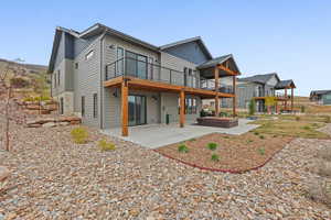 Back of property with a patio area, a deck, and a hot tub