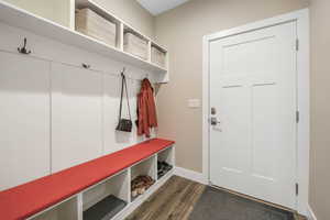 Mudroom featuring dark wood finished floors and baseboards
