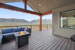 Wooden terrace with a mountain view and an outdoor living space with a fire pit