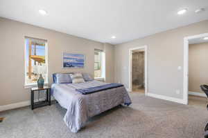 Bedroom with light colored carpet, ensuite bathroom, and recessed lighting