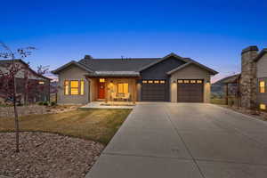 View of front of property featuring covered porch, a front yard, concrete driveway, a garage, and a shingled roof