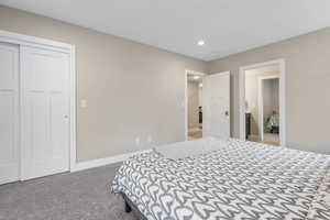 Bedroom with light colored carpet, recessed lighting, and a closet