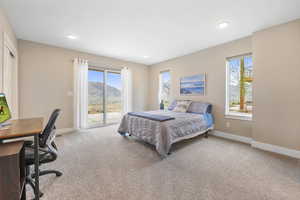 Bedroom with a desk, access to exterior, light colored carpet, a mountain view, and recessed lighting
