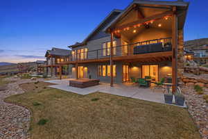Rear view of property with a patio area, a hot tub, and a lawn