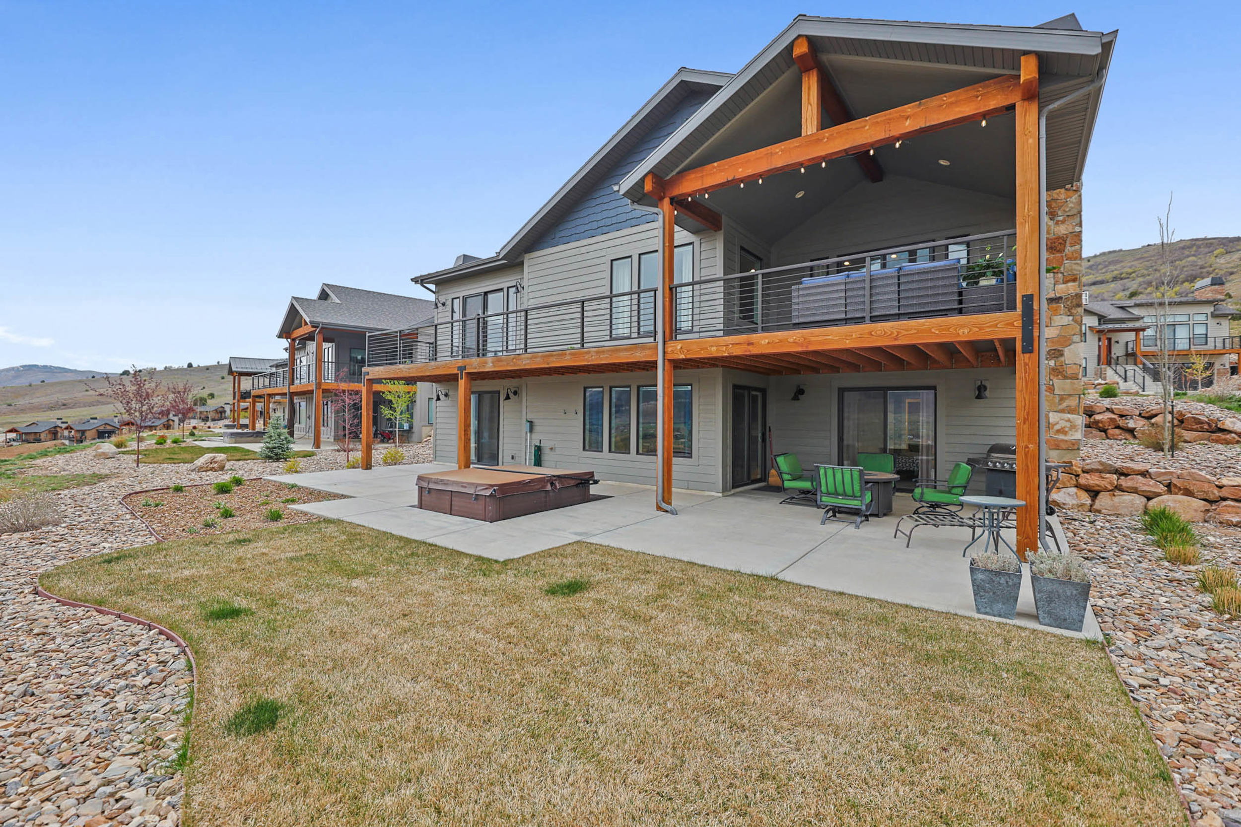 Rear view of property featuring a patio area, a lawn, and a wooden deck