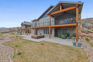 Rear view of property featuring a patio area, a lawn, and a wooden deck