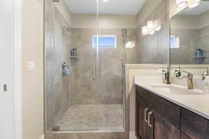 Full bath with vanity and a shower stall