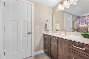 Bathroom featuring vanity, light tile patterned floors, and a shower with shower curtain