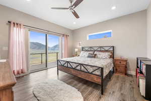Bedroom with a mountain view, wood finished floors, access to outside, ceiling fan, and recessed lighting