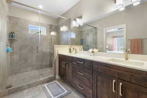Full bath with double vanity, a stall shower, and healthy amount of natural light