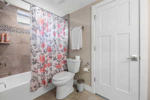 Full bath with shower / bath combination with curtain and light tile patterned floors