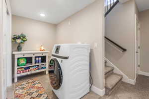 Laundry area featuring washer / dryer and light tile patterned flooring