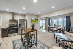 Kitchen with stainless steel appliances, dark wood finish cabinets, light countertops, recessed lighting, and open floor plan