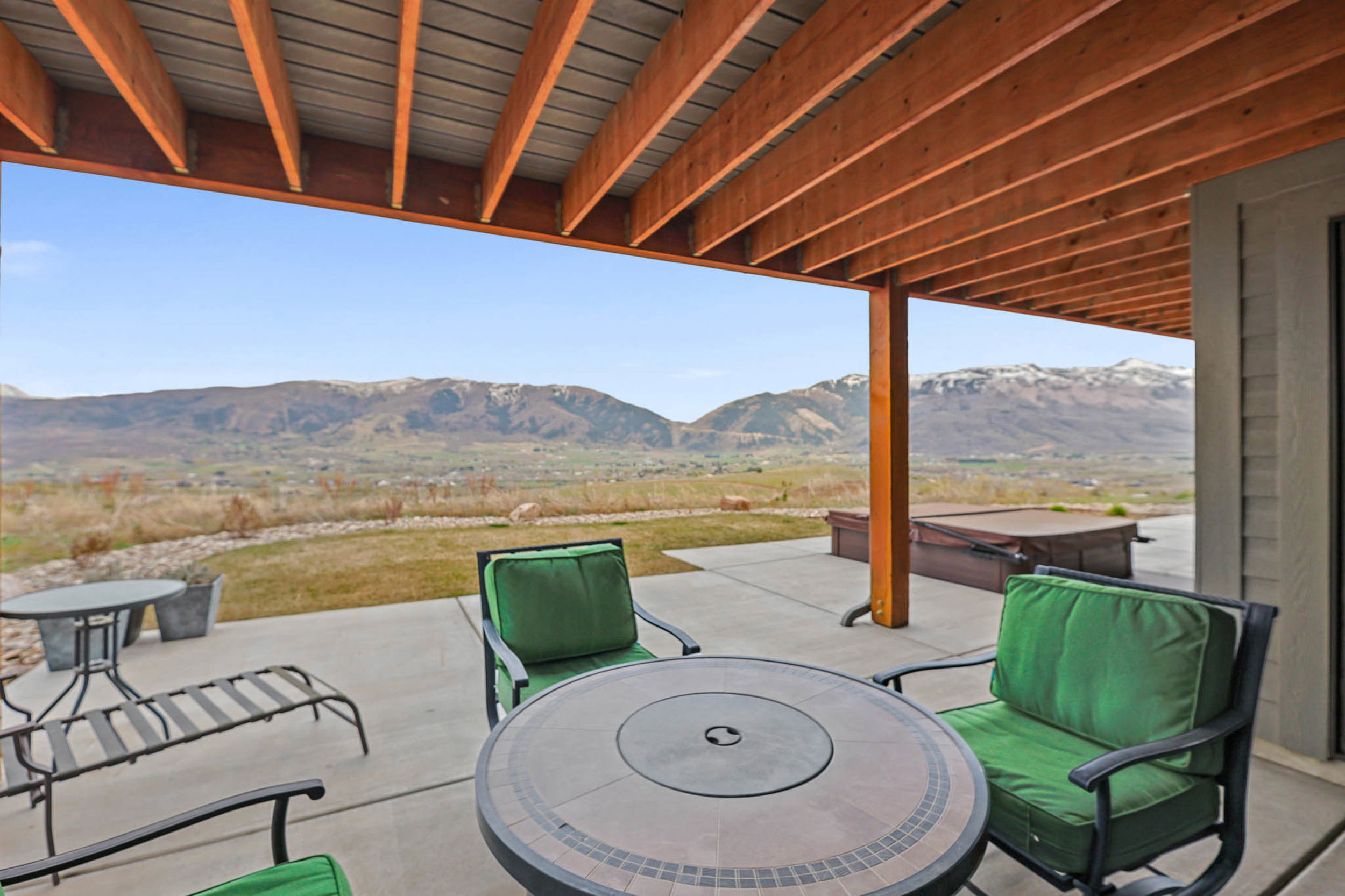 View of patio / terrace with a hot tub and a mountain view