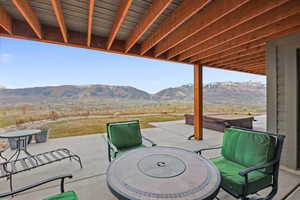 View of patio / terrace with a hot tub and a mountain view