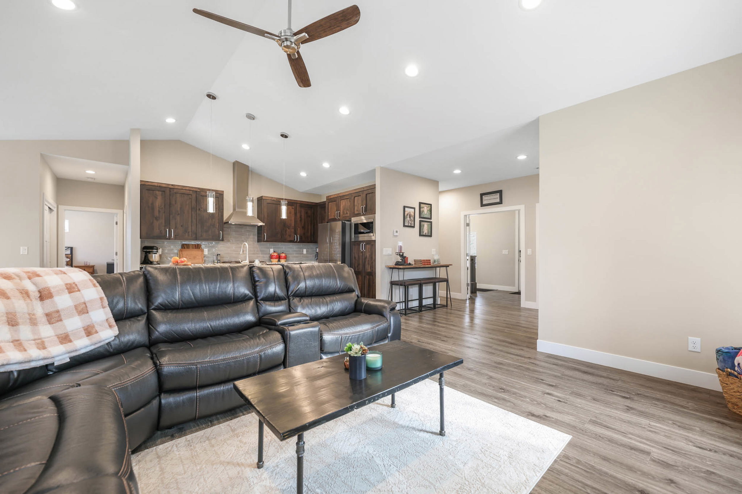 Living room featuring a ceiling fan, light wood-style flooring, recessed lighting, and vaulted ceiling
