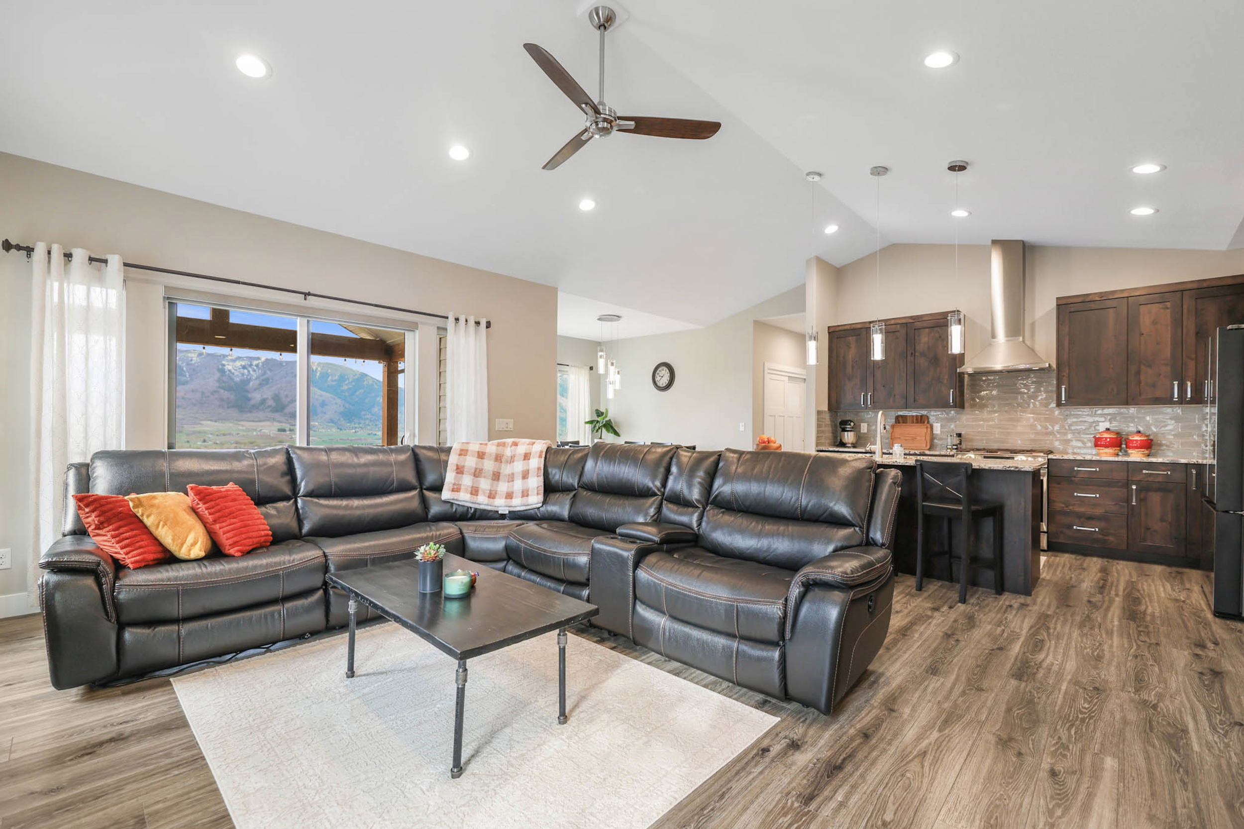 Living room featuring a ceiling fan, dark wood-style flooring, lofted ceiling, and recessed lighting