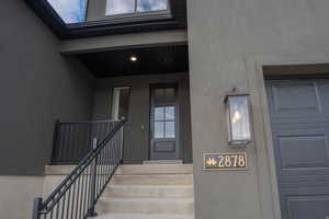 Property entrance with stucco siding and covered porch