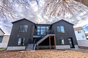 Back of property featuring a wooden deck and stucco siding