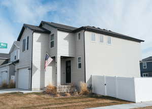 View of front facade with a garage, a gate, and concrete driveway